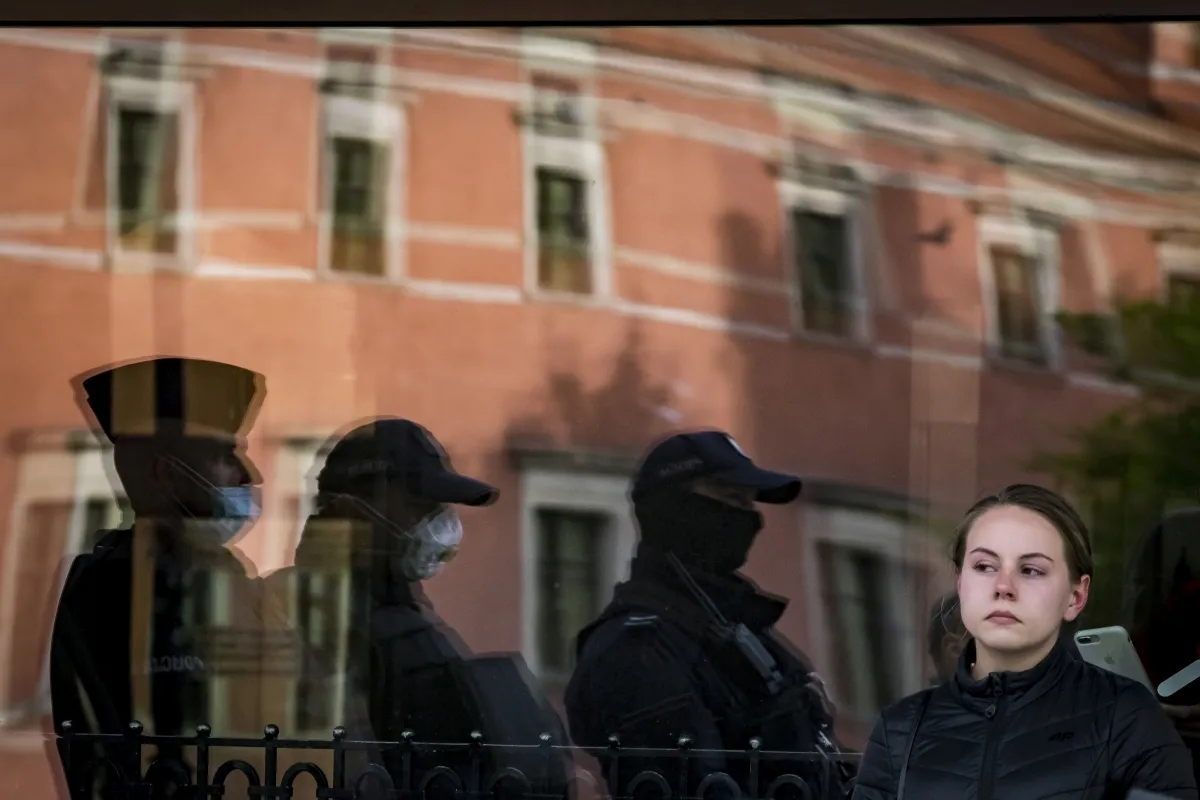 Reflections of police officers and a child in a storefront window